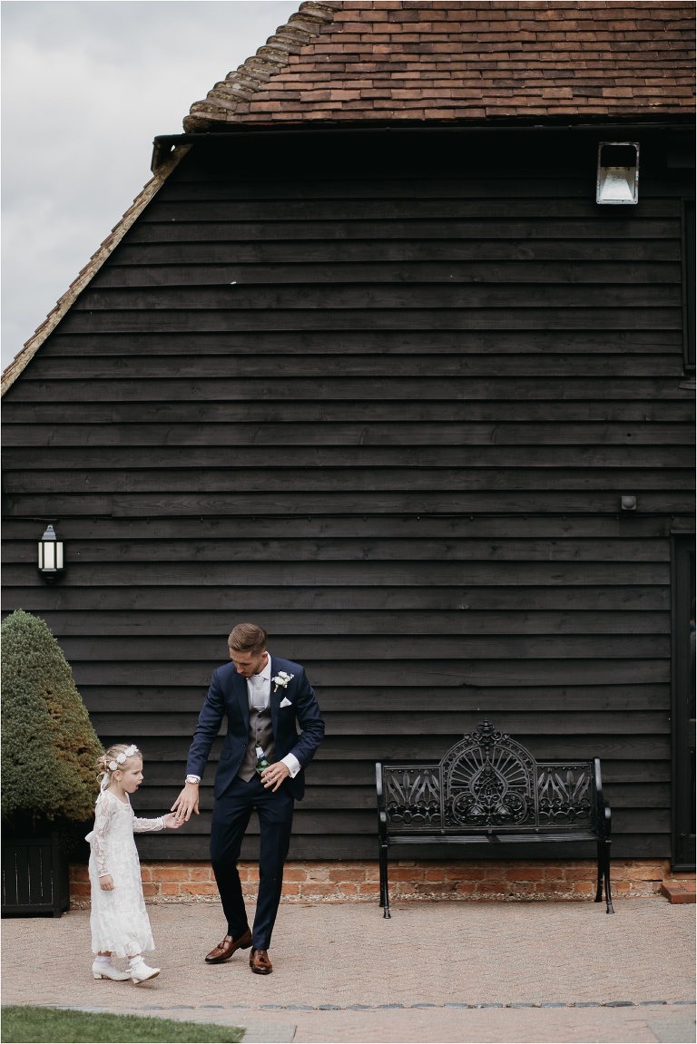 Groom and flower girl after wedding ceremony at Old Kent Barn